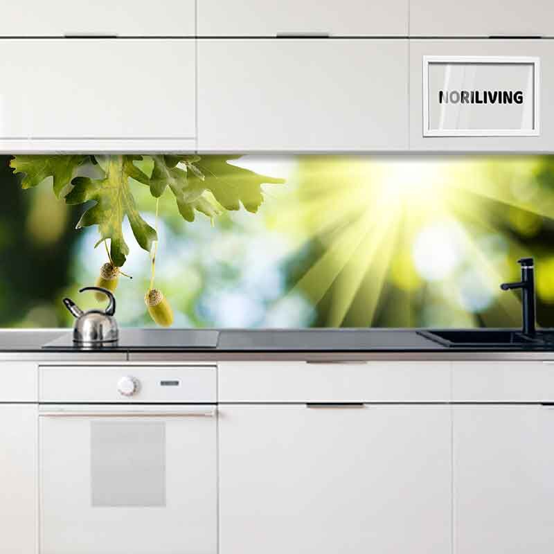 Helle Küche mit weißem Schrank und Wandbild von Eichenblättern im Sonnenlicht über der Arbeitsfläche
