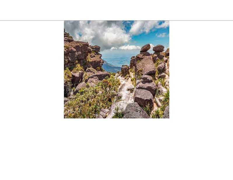 Naturpanorama mit beeindruckenden Felsen, üppiger Vegetation und blauem Himmel