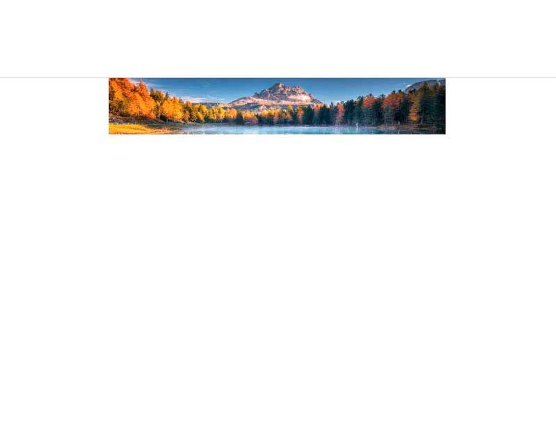 Panoramafoto einer herbstlichen Berglandschaft mit See im Vordergrund und buntem Laub