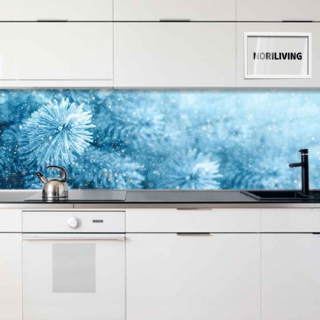 Weiße Küche mit blauem, winterlichem Spritzschutz und Teekessel auf dem Herd