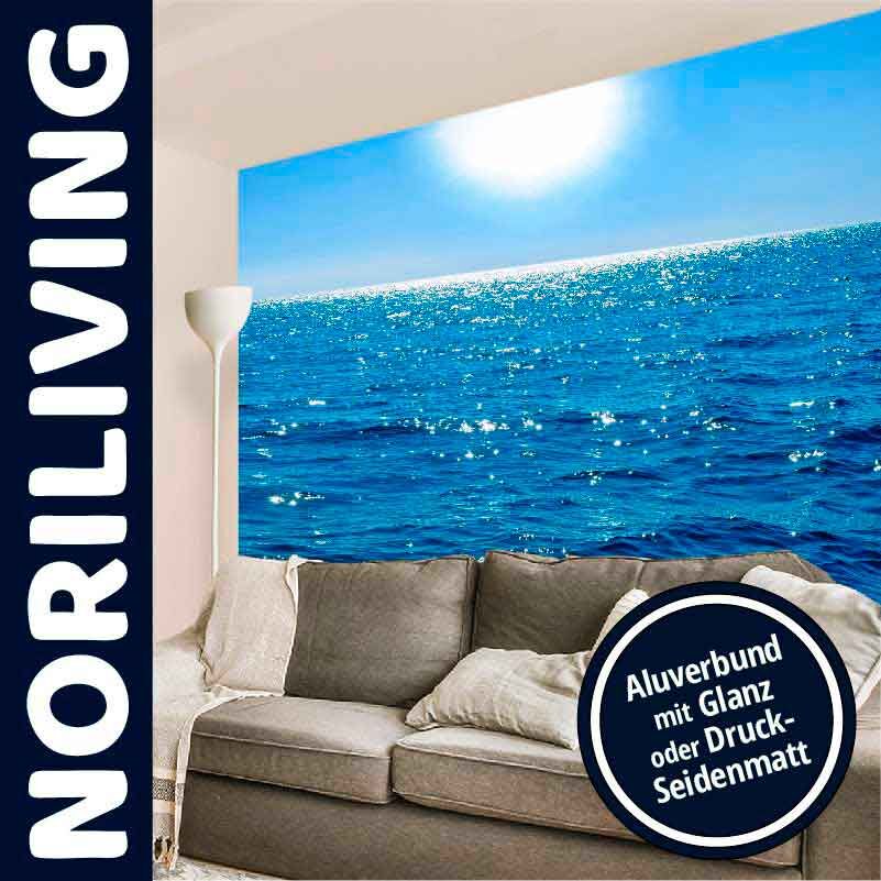 Wandbild einer strahlenden Meereslandschaft neben einer grauen Couch
