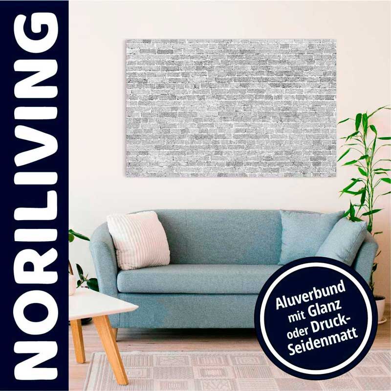 Ein stilvoll eingerichtetes Wohnzimmer mit einem blauen Sofa, dekorativen Kissen und einem an der Wand hängenden Kunstwerk in Steinoptik aus Aluverbund, wählbar im Glanz- oder Seidenmattdruck. Pflanzen und ein Beistelltisch ergänzen die Einrichtung.