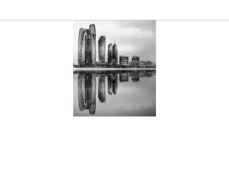 Schwarz-weiß Fotografie einer modernen Skyline mit Wolkenkratzern, die sich im ruhigen Wasser spiegeln