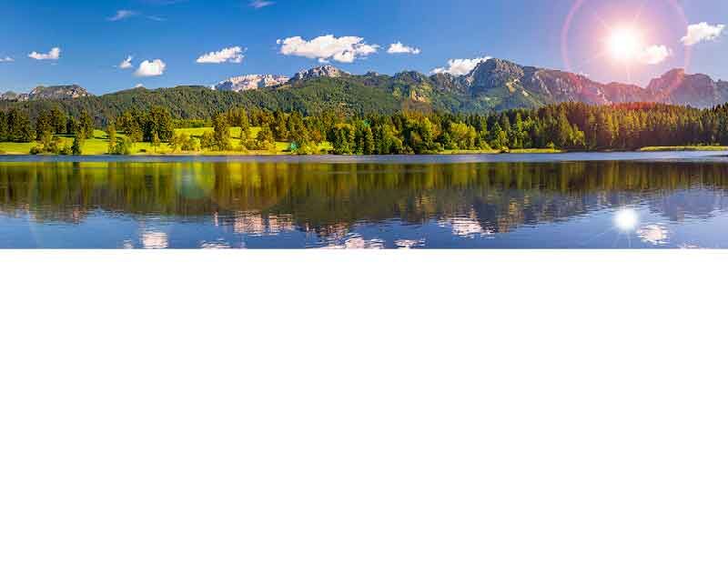 Idyllische Berglandschaft mit See und Sonnenuntergang im Hintergrund