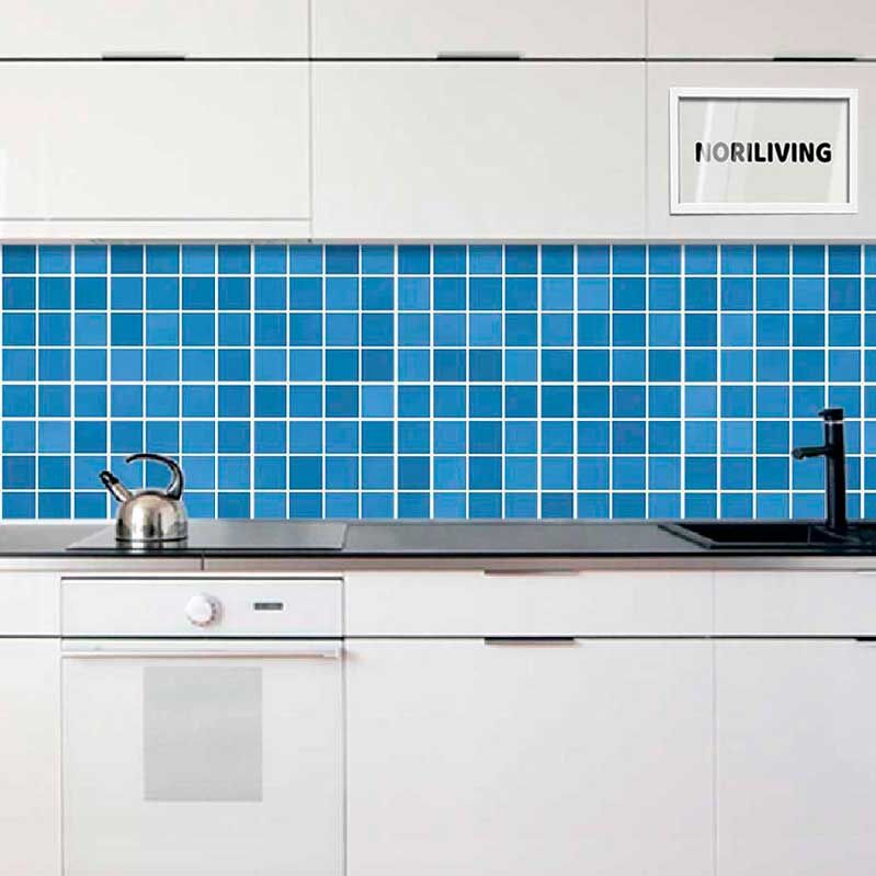 Moderne weiße Küchenschränke mit blauer Mosaikfliesenrückwand, Wasserkocher auf der Arbeitsplatte und schwarzem Wasserhahn.