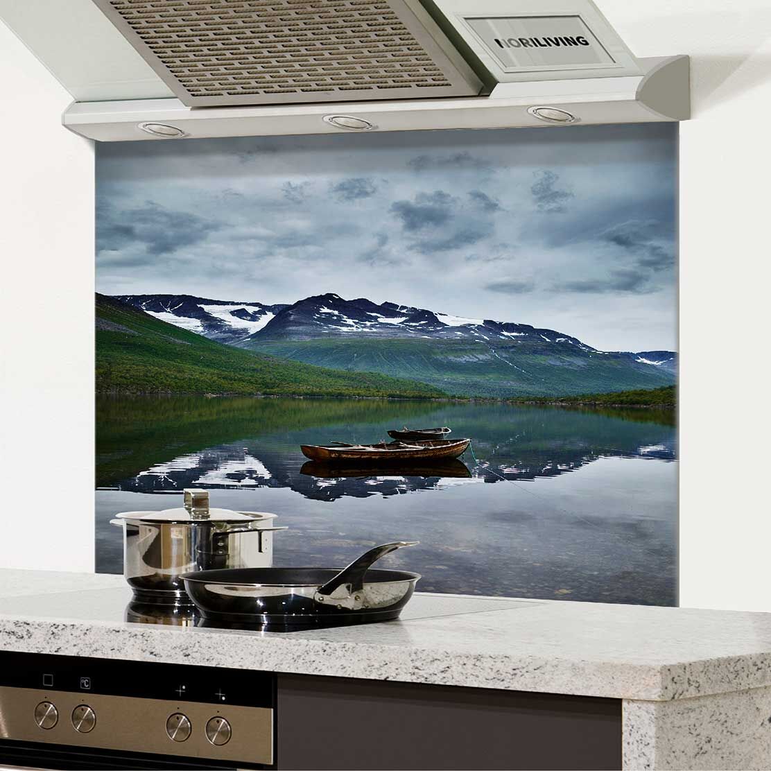 Küchenrückwand mit fotorealistischer Darstellung eines ruhigen Bergsees mit Boot und schneebedeckten Bergen im Hintergrund.