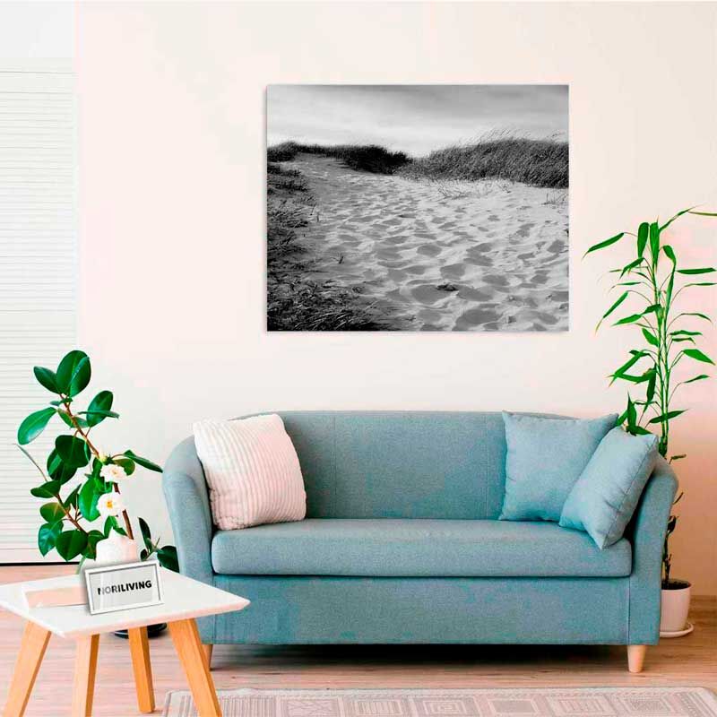 Wohnzimmer mit einem blauen Sofa, einem niedrigen Holztisch und einem Schwarz-Weiß-Foto an der Wand